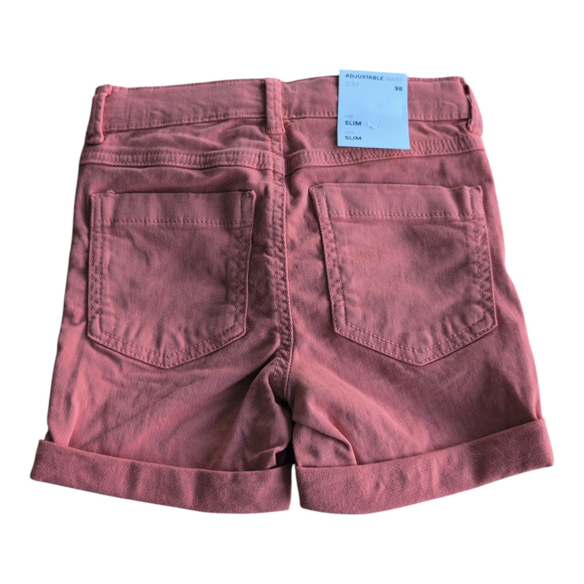 Pierrot Outlet kinder shorts in koraalroze katoen met verstelbare taille en omgeslagen broekspijpen. Klassieke vijf-zakken-stijl.