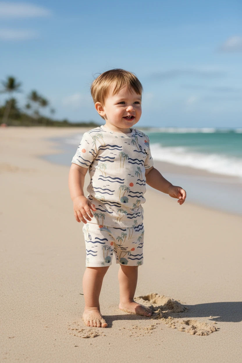 Pierrot Outlet zomer pyjamaset voor peuters, crème met palmbomenprint, geribd katoen, korte mouwen en broek.