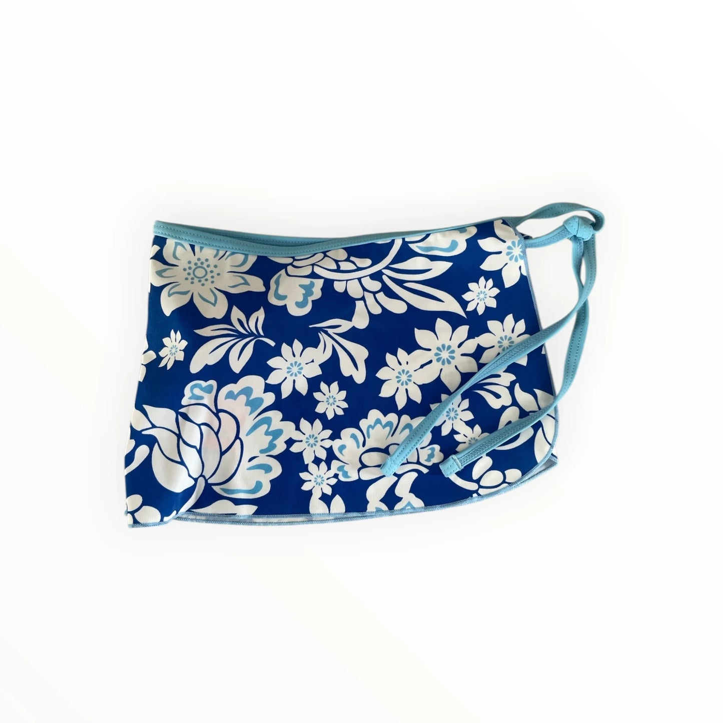 Pierrot Outlet wikkelrok in blauw en wit met bloemenprint, lichtblauwe bies en handige striksluiting voor op het strand.
