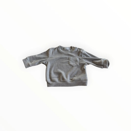 Pierrot Outlet baby meisjes trui met lange mouwen in zacht grijs fleece, met borstzak en drukknoopsluiting op de schouder.