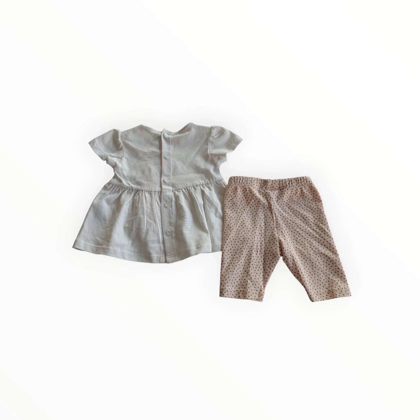 Pierrot Outlet babykleding set: wit jurkje met dierenprint en knoopjes, roze legging met stippen. Comfortabel en stijlvol.