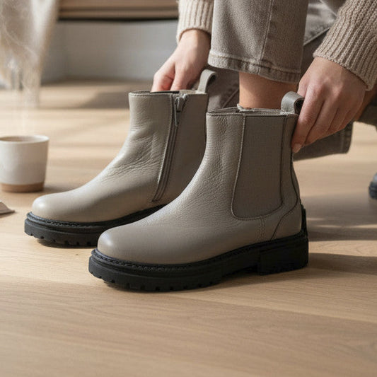 Pierrot Outlet beige leren enkellaarsjes met robuuste profielzool en ritssluiting, gedragen in een sfeervol interieur.