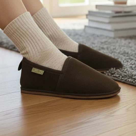 Pierrot Outlet bruine suède pantoffels met warme voering en flexibele zool gedragen in een gezellige woonkamer