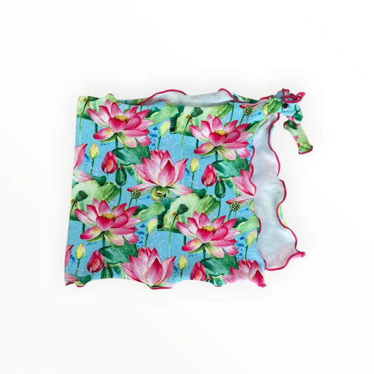 Pierrot Outlet dames sarong met roze lotusbloemen, groene bladeren en een golvende roze rand op een blauwe achtergrond.