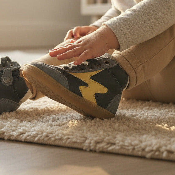 Pierrot Outlet kindersneakers van donkerblauw leer en suède met een opvallende gele bliksemschicht aan de zijkant.