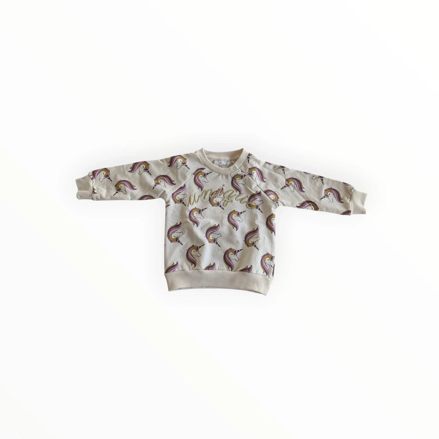 Pierrot Outlet crèmekleurige sweater met all-over eenhoornprint en gouden glittertekst 'Dream Big'.