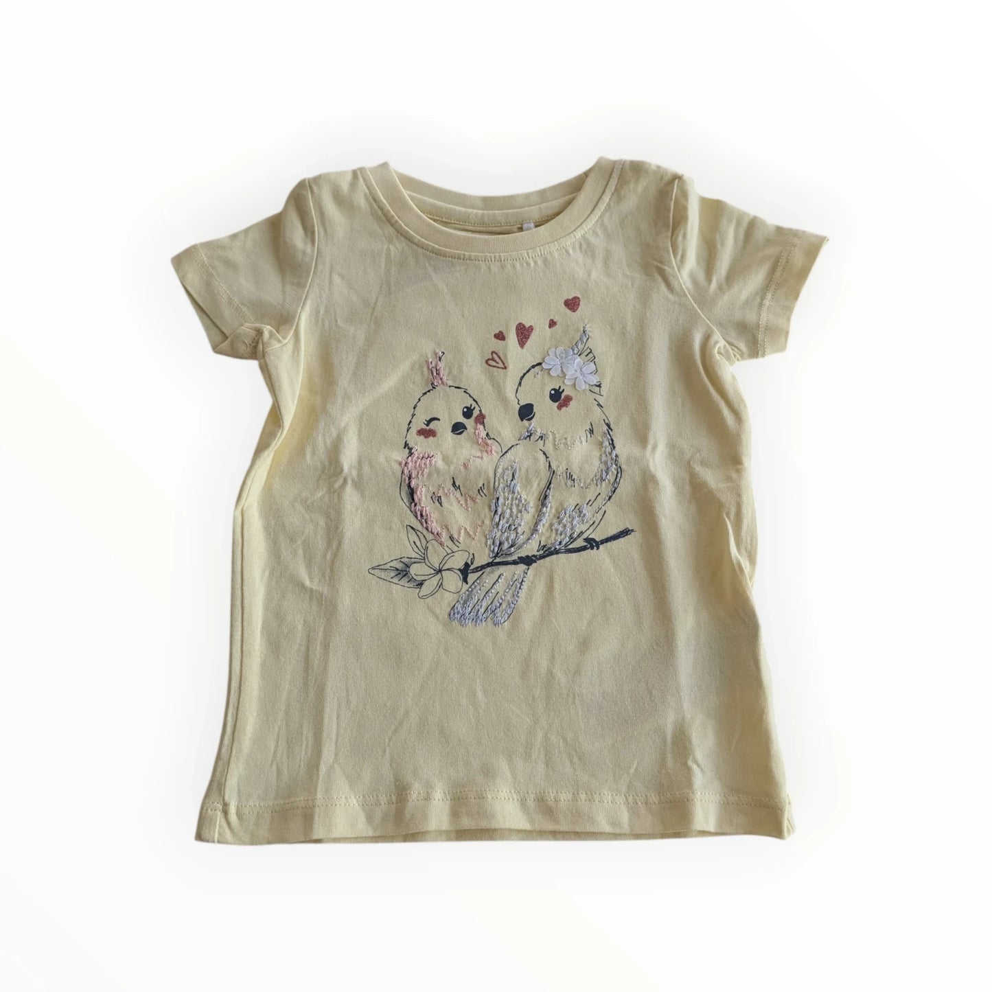 Pierrot Outlet geel katoenen T-shirt met korte mouwen en geborduurde vogelprint met hartjes. Kinderkleding.