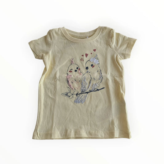 Pierrot Outlet geel katoenen T-shirt met korte mouwen en geborduurde vogelprint met hartjes. Kinderkleding.