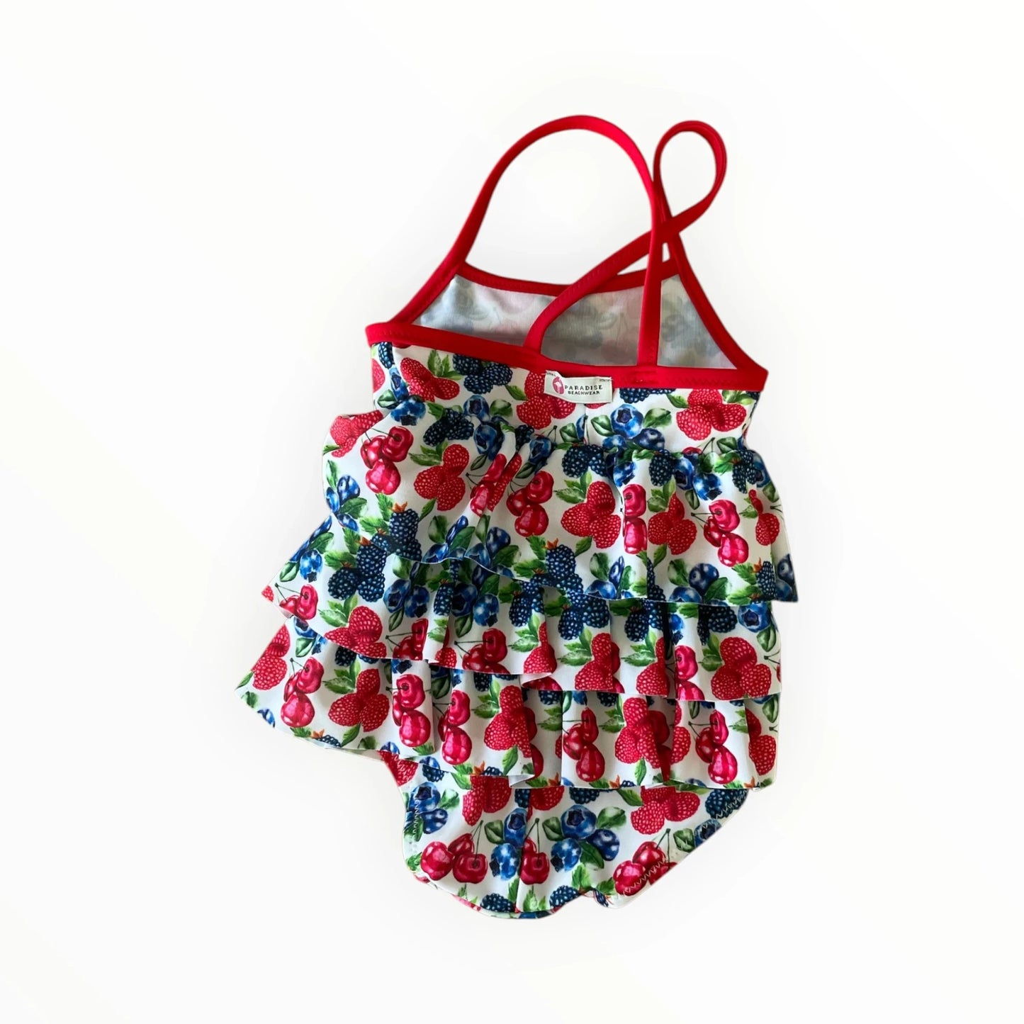 Pierrot Outlet gelaagd kinderzwempak met fruitmotief, kersenprint, ruches en rode gekruiste schouderbandjes.