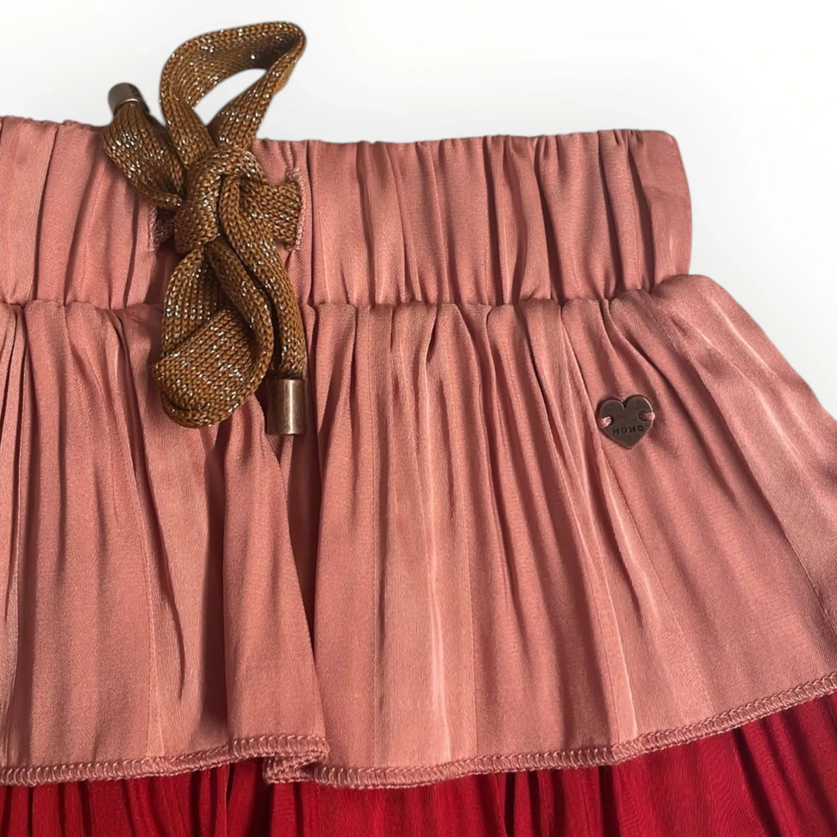 Pierrot Outlet gelaagde rok in roze en rood met elastische tailleband, glinsterend strikdetail en hartvormig embleem.