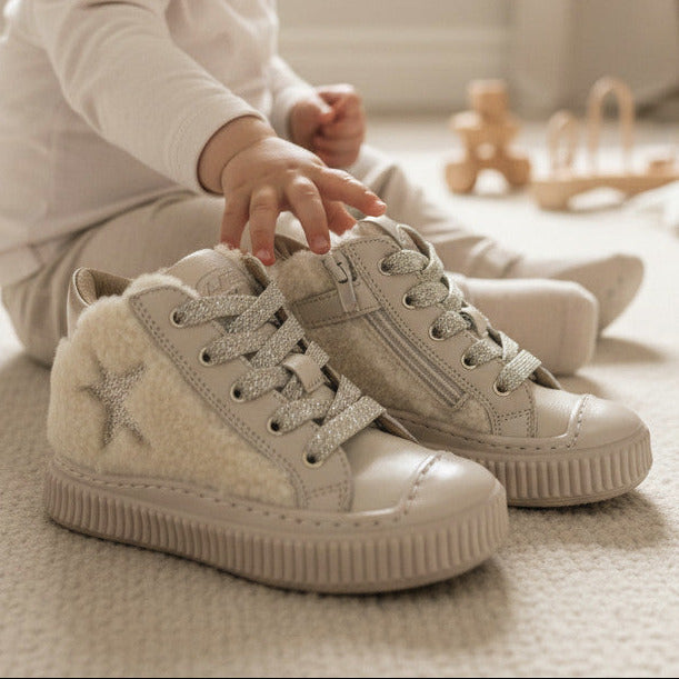Pierrot Outlet gevoerde champagnekleurige hoge sneakers met sterdetail en teddyvoering voor kinderen in een babykamer