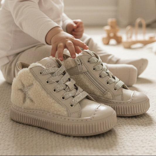 Pierrot Outlet gevoerde champagnekleurige hoge sneakers met sterdetail en teddyvoering voor kinderen in een babykamer