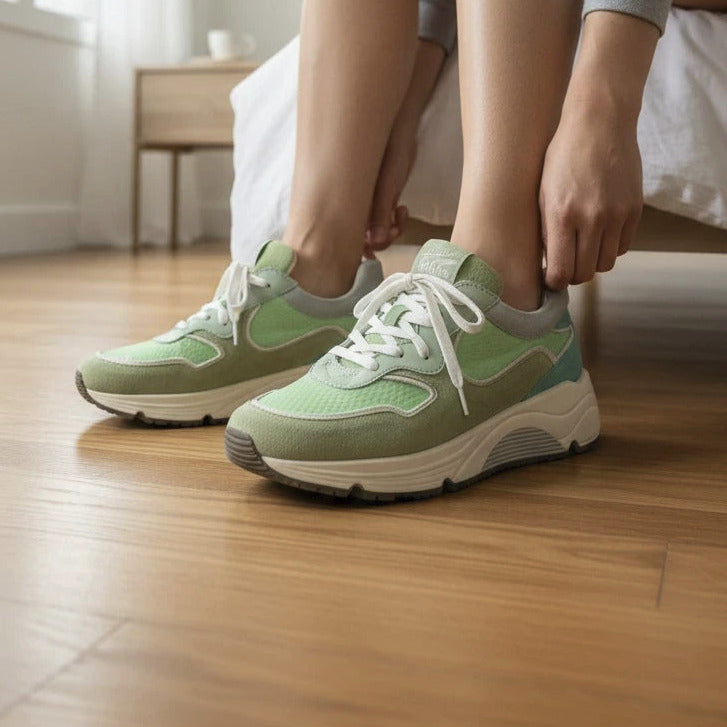 Pierrot Outlet sportieve sneakers in groentinten van suède en textiel, gedragen door een vrouw in een slaapkamer.