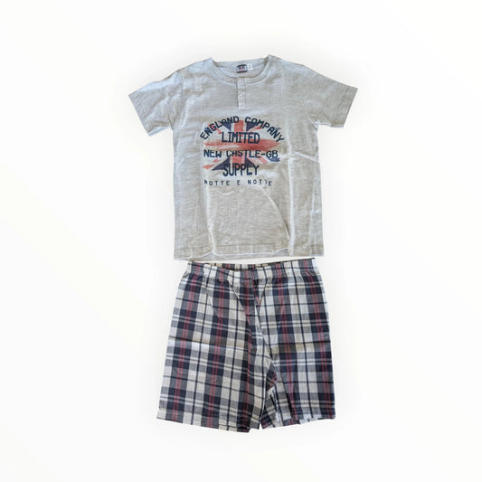 Pierrot Outlet jongens pyjamaset met lichtgrijs T-shirt met korte mouwen en geruite short. T-shirt met knoopsluiting en print.