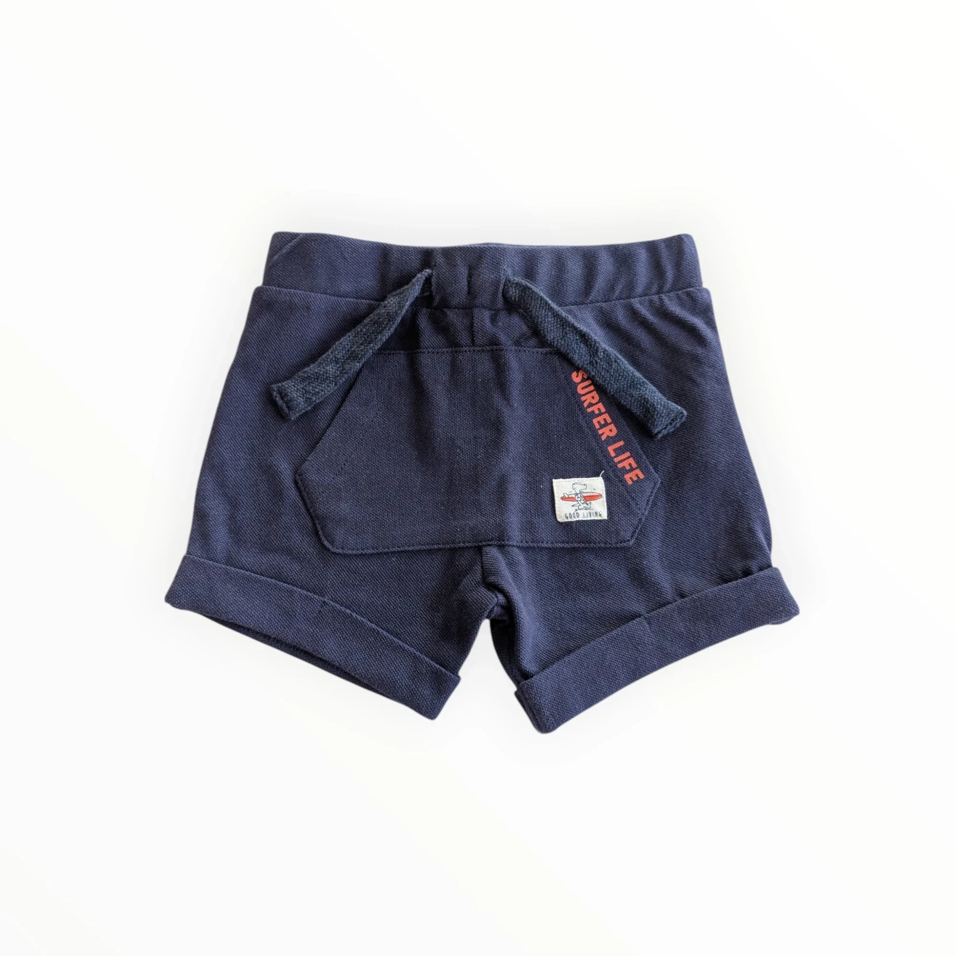 Pierrot Outlet navy blauwe katoenen jongens shorts met 'Surfer Life' print, trekkoord en opgerolde broekspijpen.