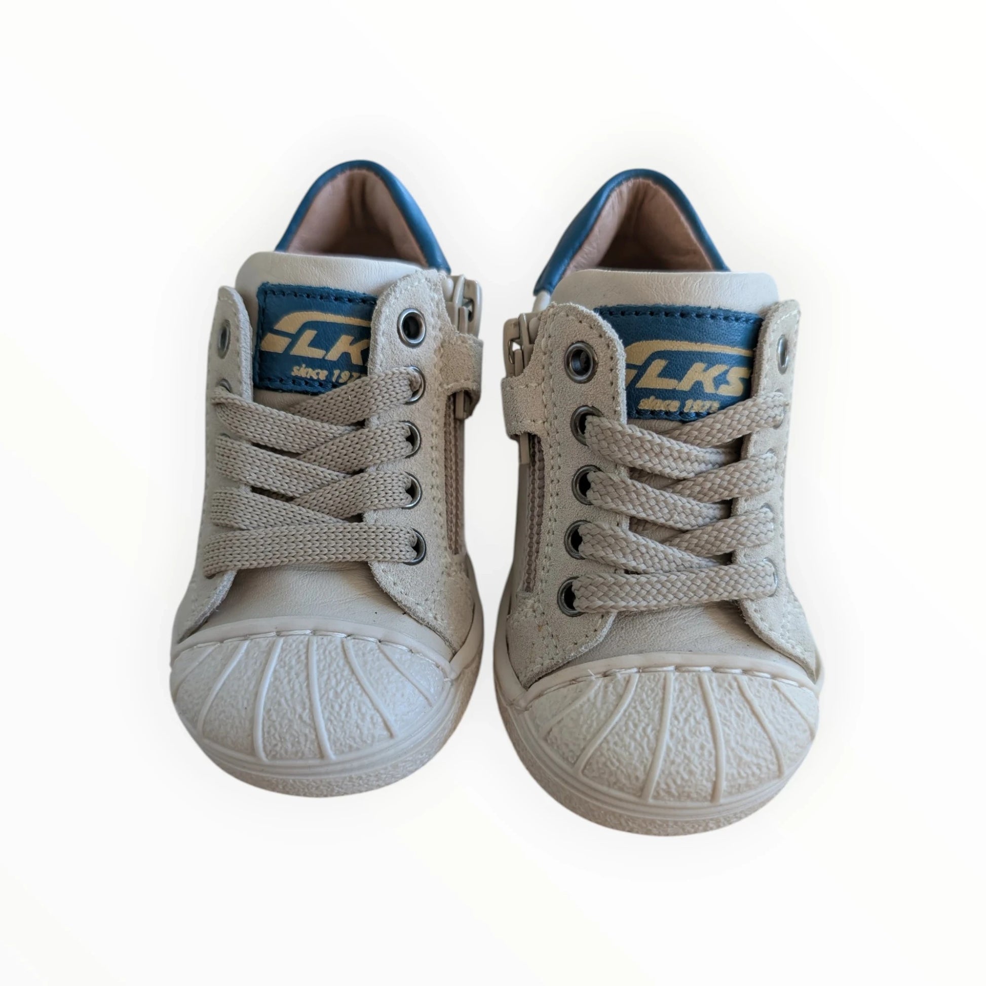 Pierrot Outlet beige leren kindersneakers met sterdetail, ritssluiting en veters. Blauwe accenten op de tong en hiel.