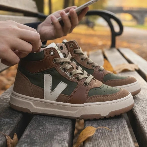 Pierrot Outlet hoge sneakers voor kinderen in olijfgroen en bruin suède met veters en ritssluiting op een parkbank.