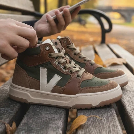 Pierrot Outlet hoge sneakers voor kinderen in olijfgroen en bruin suède met veters en ritssluiting op een parkbank.
