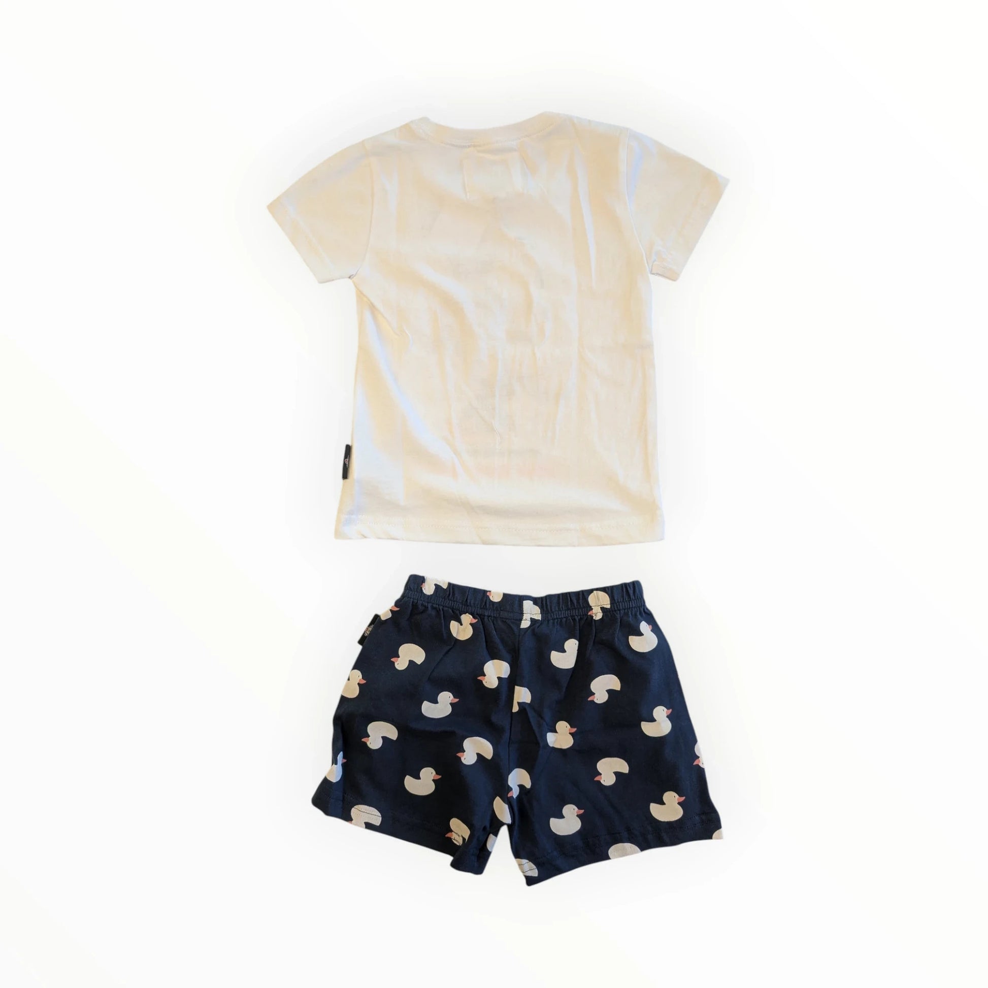 Pierrot Outlet kinder T-shirt en korte broek met eendenprint. Wit katoenen T-shirt met korte mouwen en donkerblauwe shorts met eendenprint.