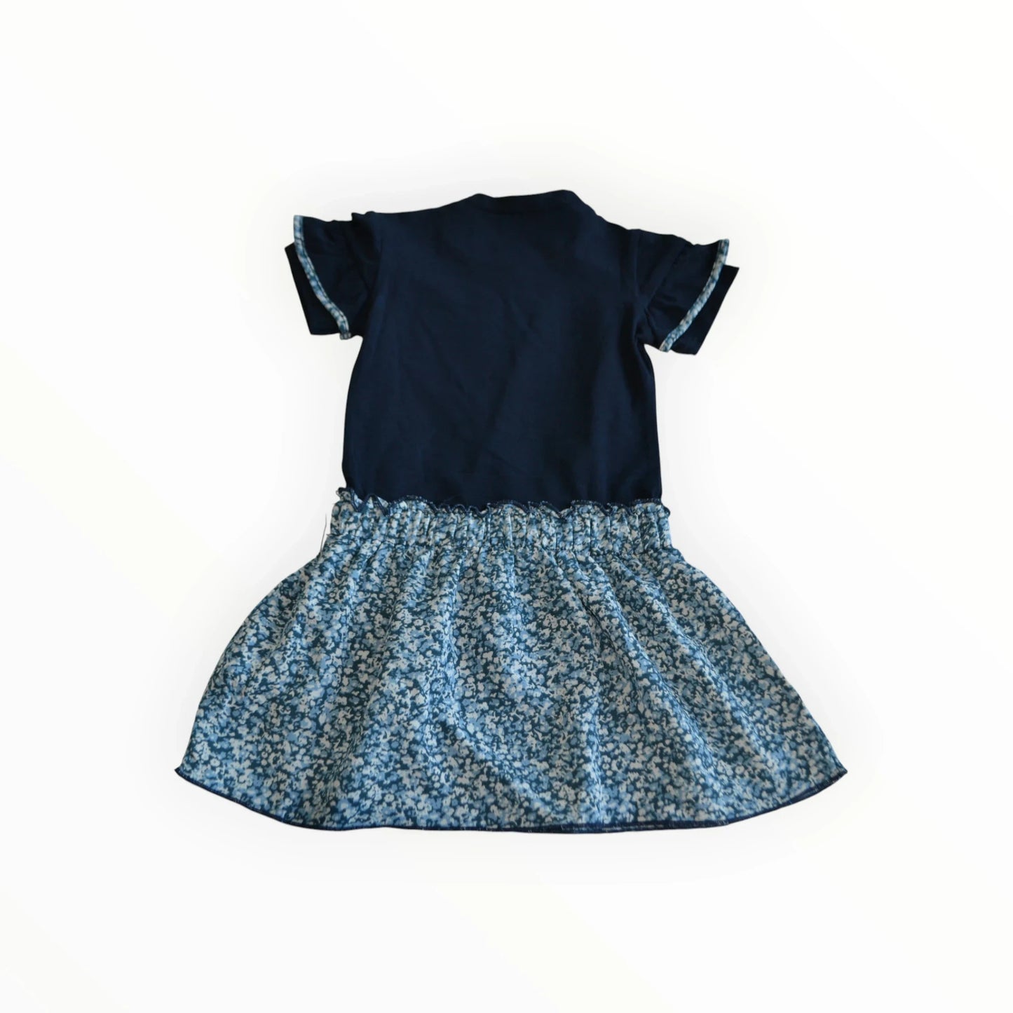 Pierrot Outlet donkerblauwe kinderjurk met korte ruche mouwen en lichtblauwe bloemenprint rok.