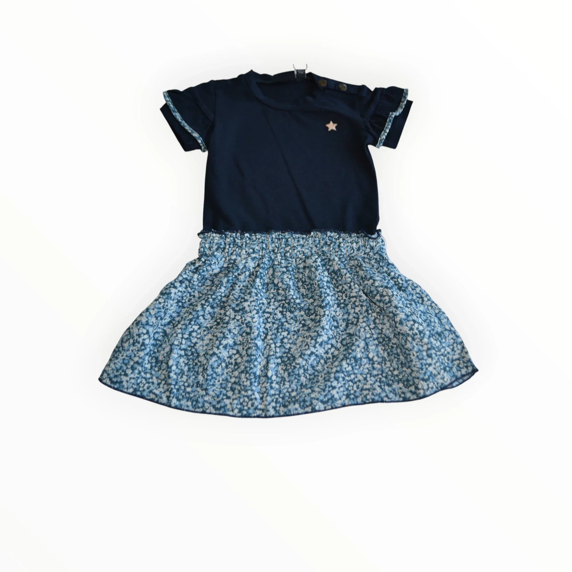 Pierrot Outlet donkerblauwe kinderjurk met korte ruche mouwen, gouden ster en lichtblauwe bloemenprint rok.