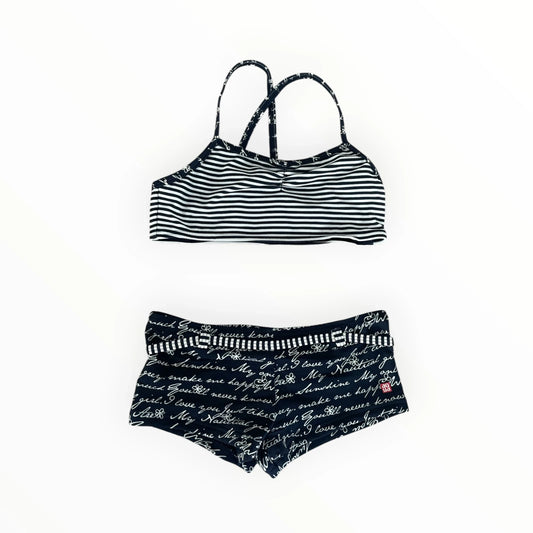 Pierrot Outlet tweedelige bikini voor meisjes in marineblauw met gestreepte top en broekje met tekstprint en riempje.