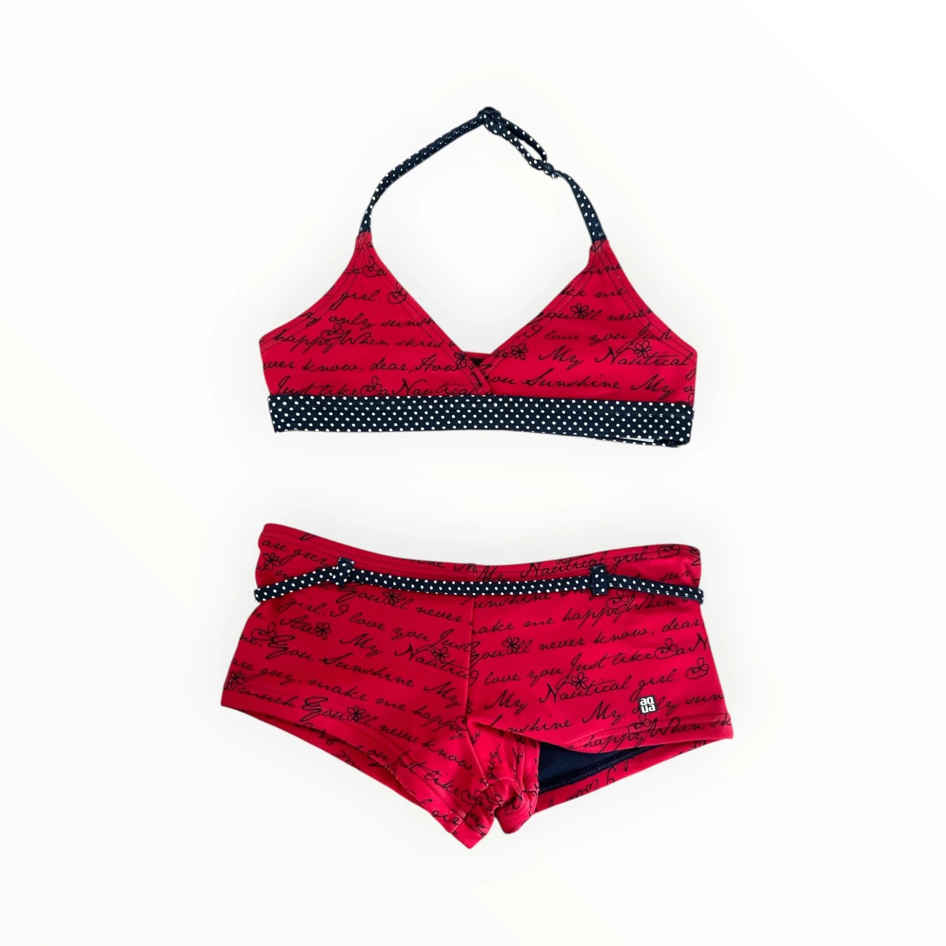 Pierrot Outlet rode bikini voor meisjes met tekstprint, bloemetjes en donkerblauwe stippendetails voor op het strand.