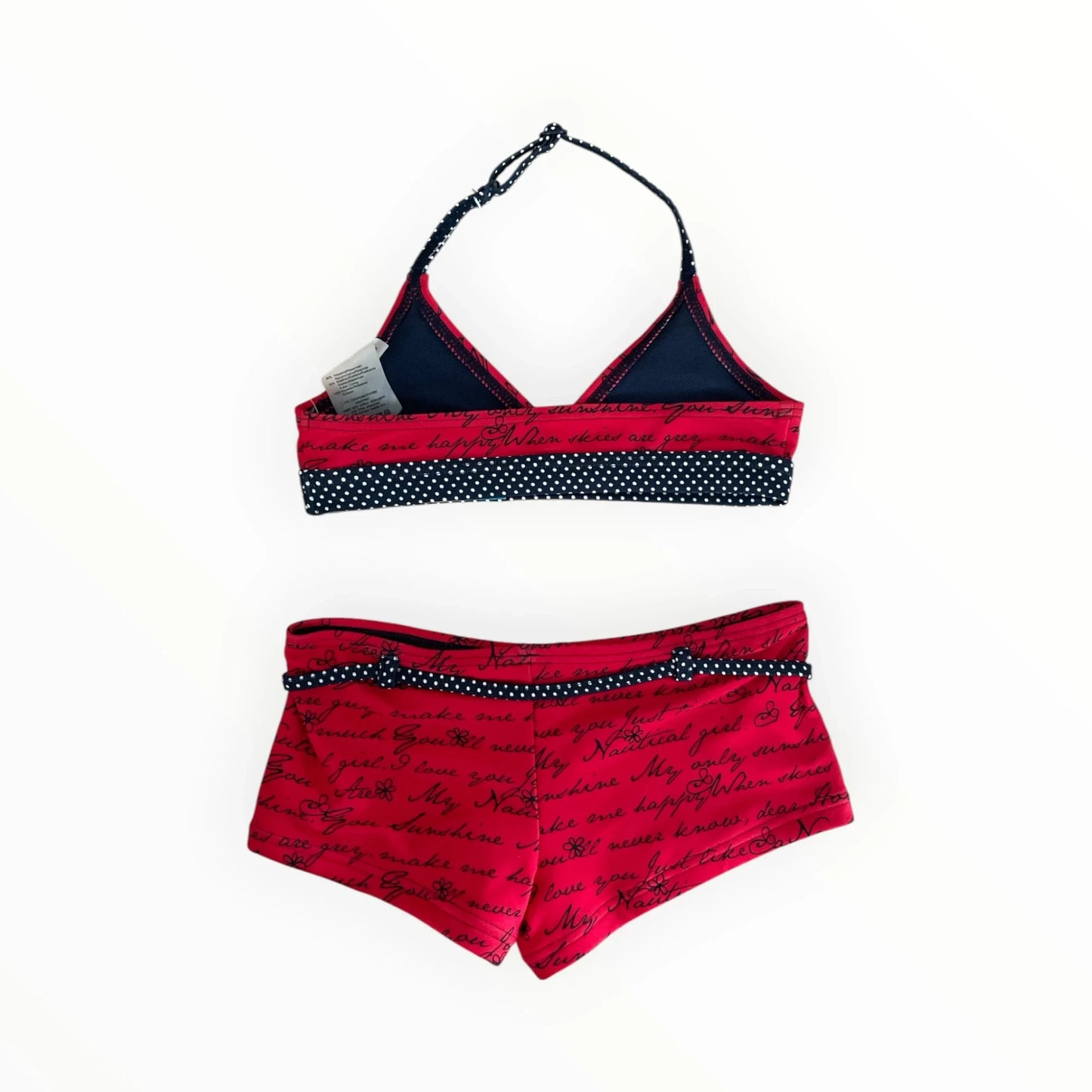 Pierrot Outlet rode bikini voor meisjes met tekstprint, bloemetjes en donkerblauwe stippendetails.