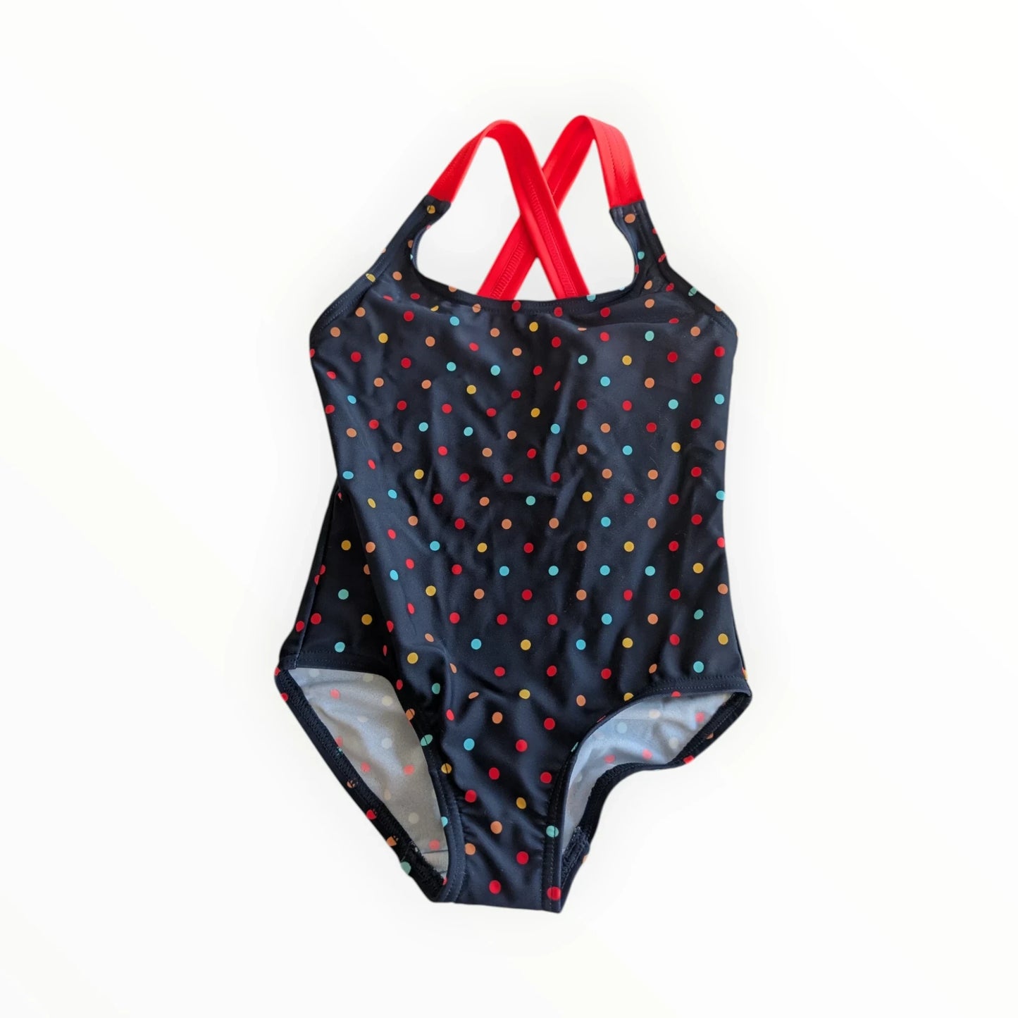 Pierrot Outlet meisjesbadpak met stippenpatroon en rode bandjes, kruis op de rug. Diepblauw met veelkleurige stippen.