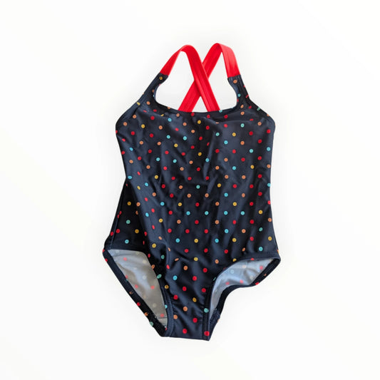 Pierrot Outlet meisjesbadpak met stippenpatroon en rode bandjes, kruis op de rug. Diepblauw met veelkleurige stippen.