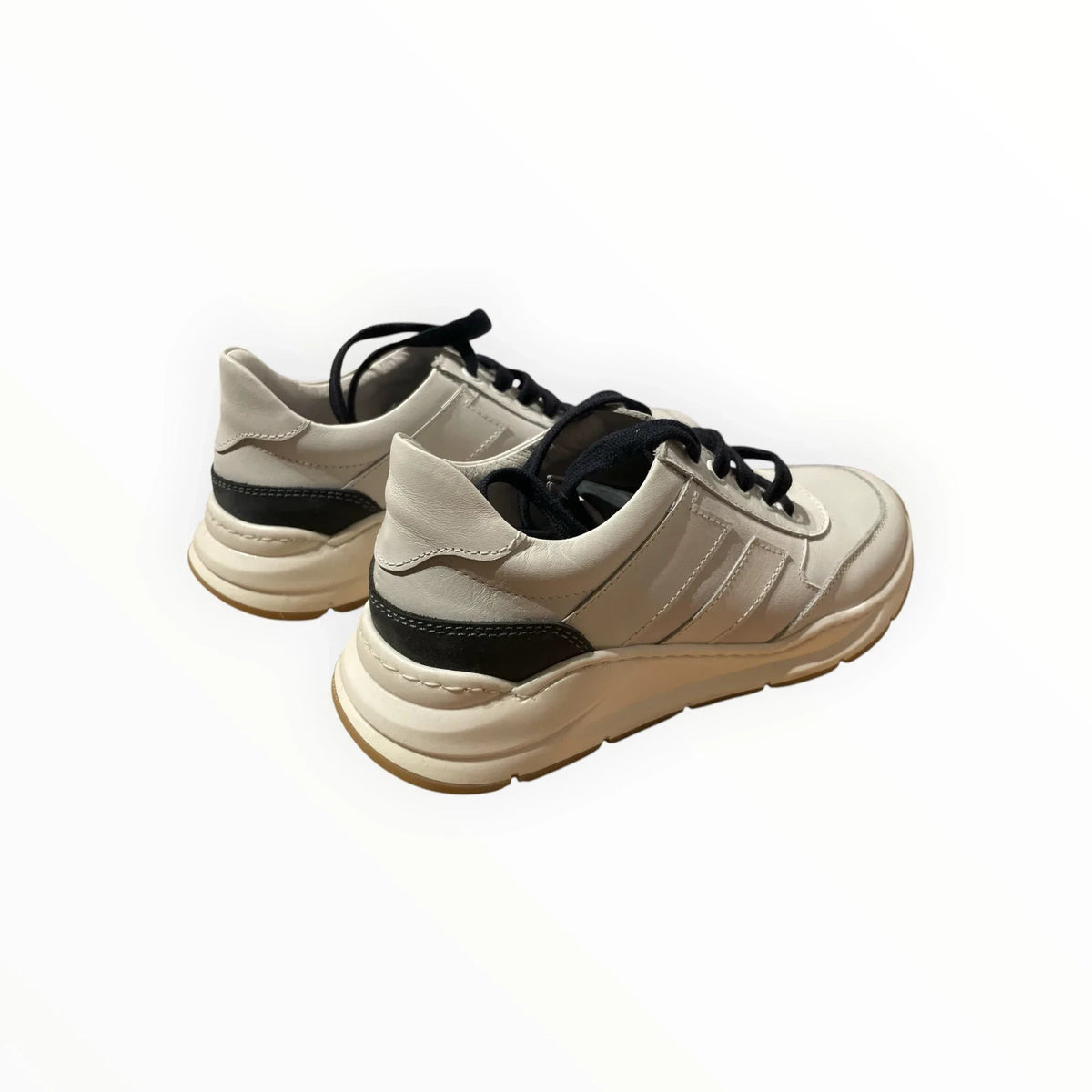 Pierrot Outlet luxe off-white leren damessneakers met zwarte veters en donkere hielaccenten op een witte achtergrond.