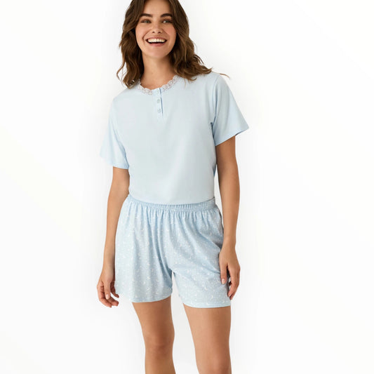 Pierrot Outlet lichtblauwe pyjamaset met korte mouwen, kanten kraag en maanprint shorts. Zacht en comfortabel.