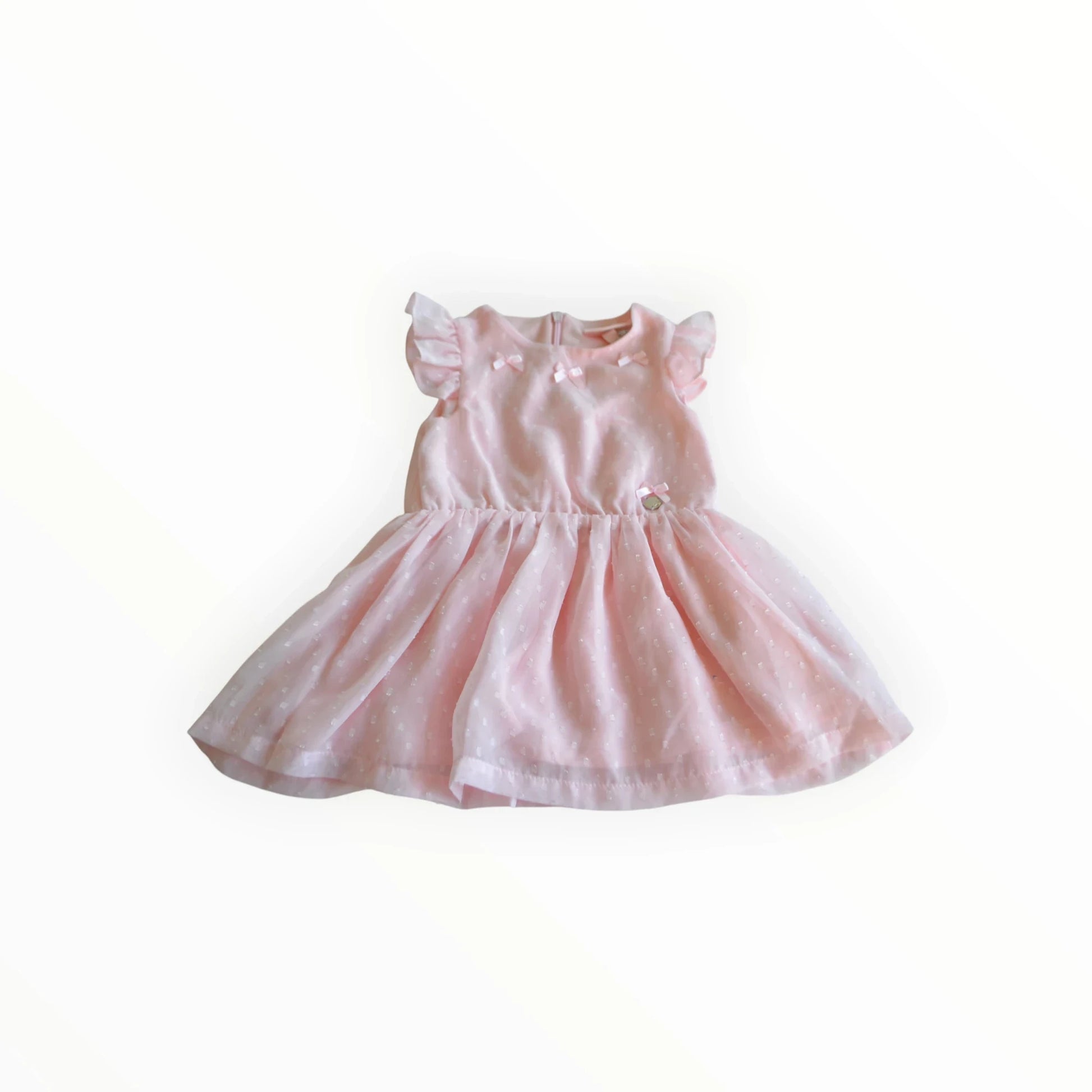 Pierrot Outlet roze kinderjurk met witte stippen, strikjes en pofmouwtjes. Licht doorschijnende stof.