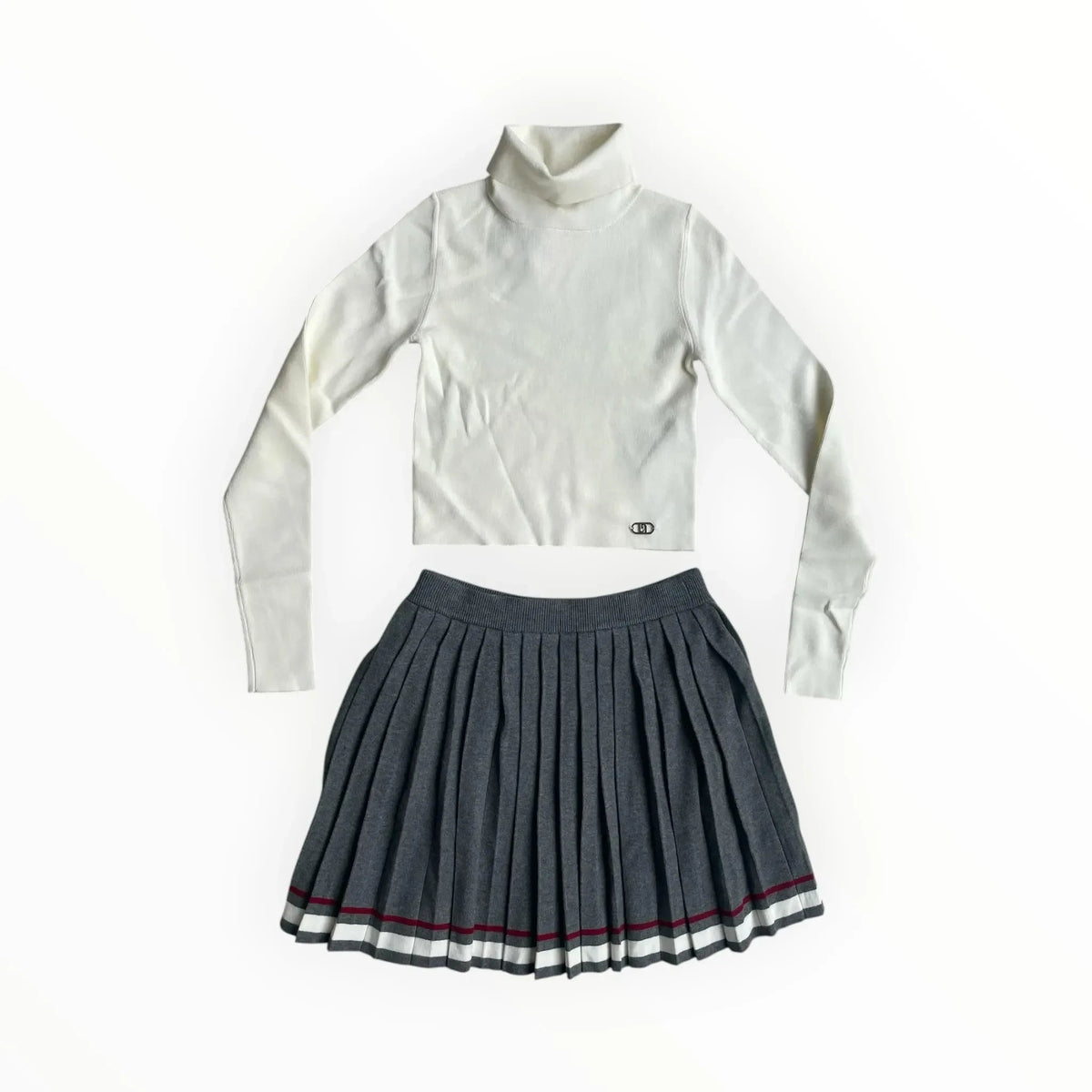 Pierrot Outlet tweedelige set met witte coltrui en grijze plooirok met sportieve bies in wit en rood.