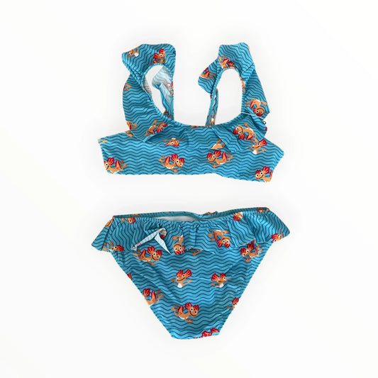 Blauwe Woody tweedelige bikini voor kinderen met golvend patroon, zwemmende figuurtjes en schattige ruches bij Pierrot Outlet.