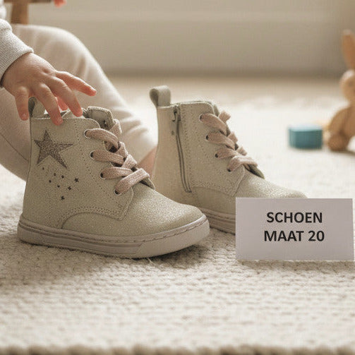 Pierrot Outlet zandkleurige glinsterende enkellaarsjes met ster-detail en veters voor kinderen op een speelkleed