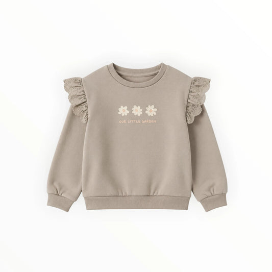 Pierrot Outlet zandkleurige kindersweater met ruches op de schouders, broderie-details en bloemenprint op de voorzijde.