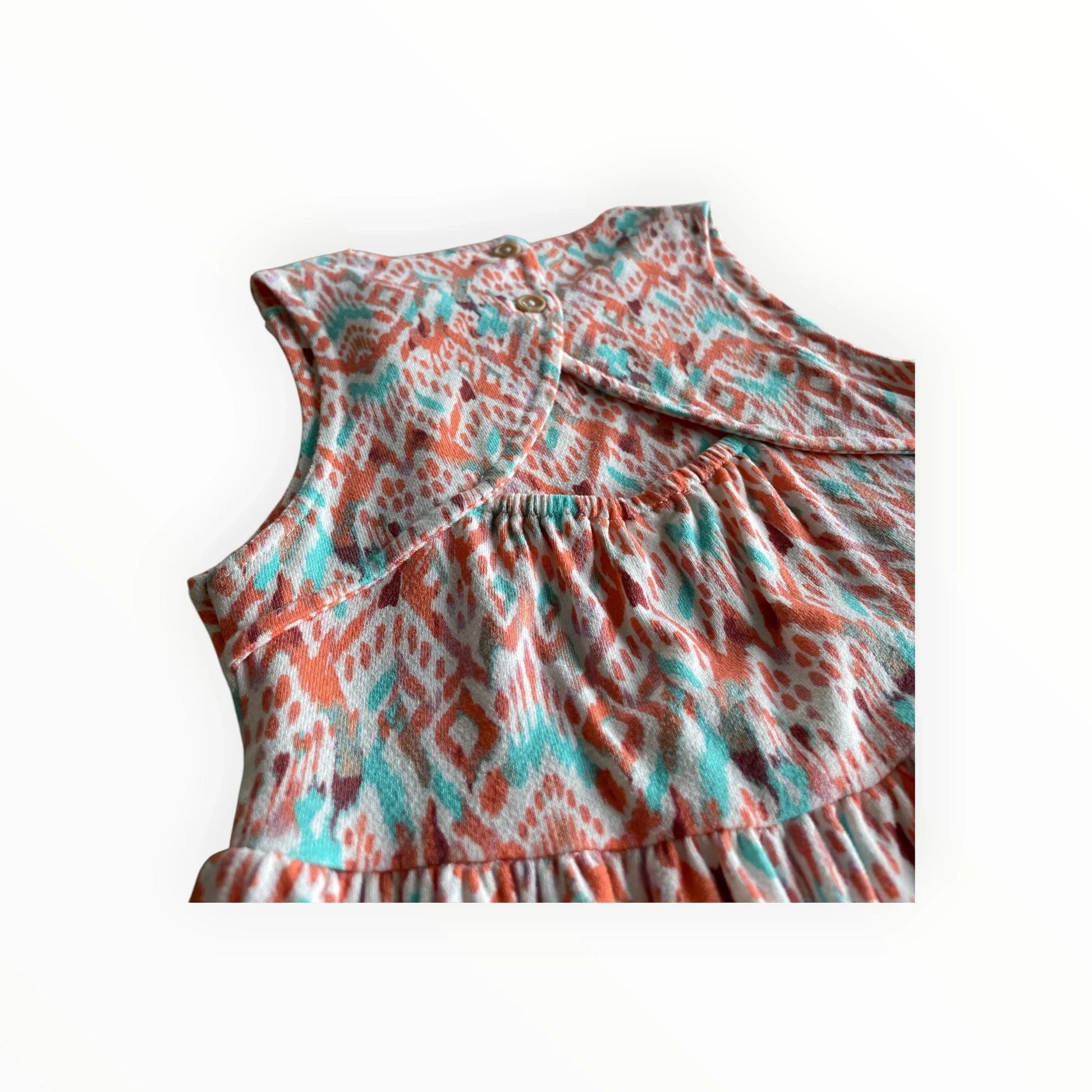 Pierrot Outlet zomerjurk met oranje, turquoise en witte etnische print. Mouwloos, gelaagde rok, ronde hals met knoopsluiting.