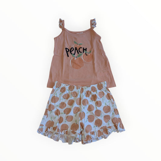 Pierrot Outlet zomerse pyjamaset voor kinderen met roze hemdje met perzikopdruk en bijpassende shorts met ruches.