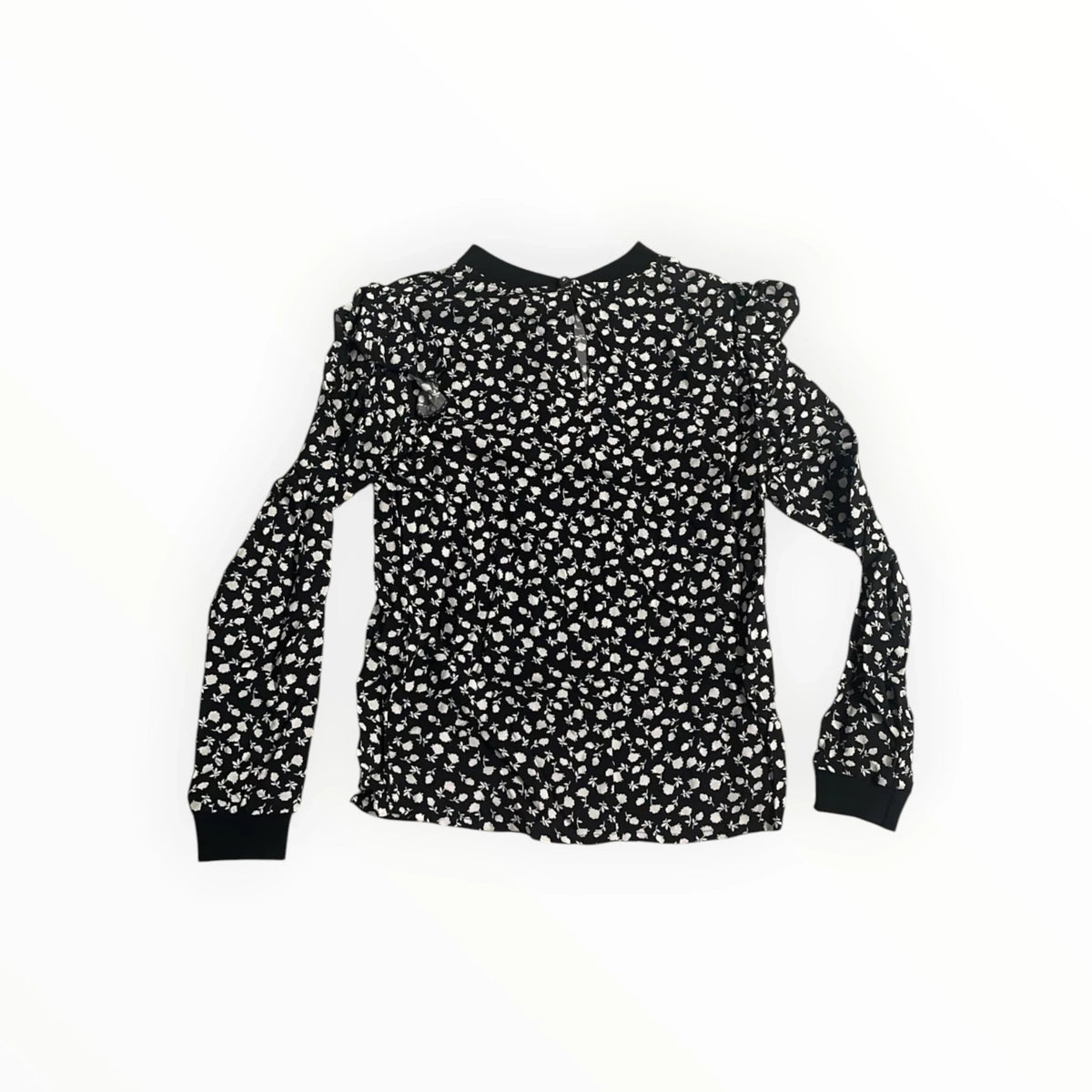 Pierrot Outlet damesblouse met zwarte basis, wit bloemmotief, lange mouwen en ruches op de schouders.