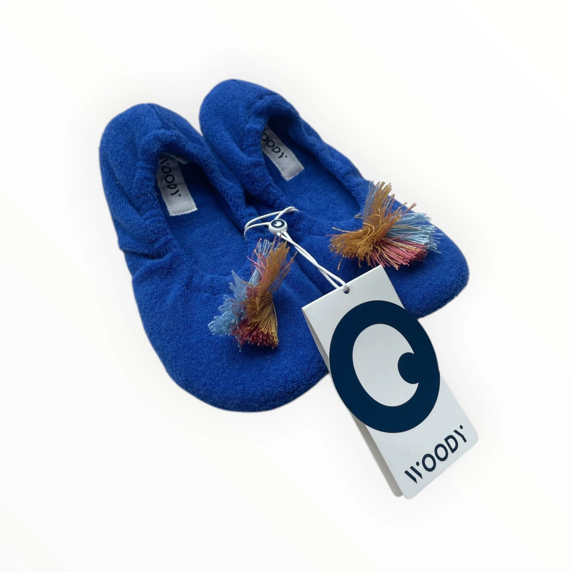 WOODY dames pantoffels in levendig blauw met pompon details en elastische sluiting. Gemaakt van zachte stof voor ultiem comfort thuis.